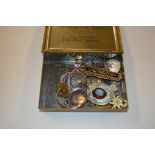 A tin of assorted jewellery to include brooches, l