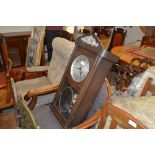 An oak cased two hole wall clock