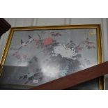 An oriental framed print depicting birds amongst f