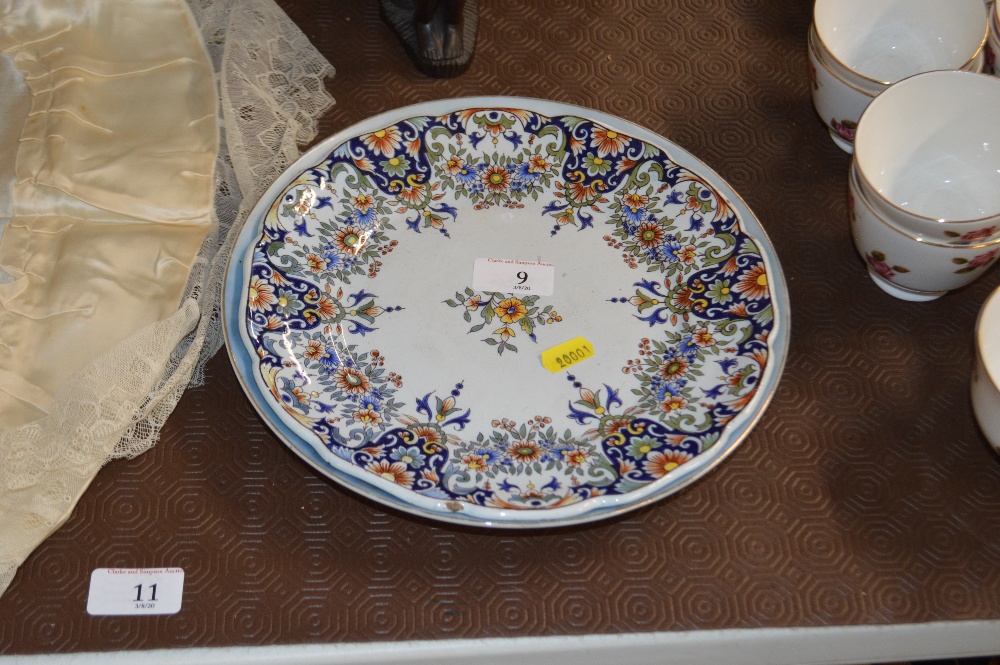 A Faience style pottery plate decorated with flowe