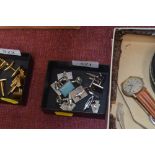 A box of various cufflinks