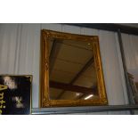 An antique gilt picture frame with later mirror