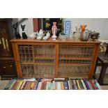 An oak and leaded glazed side cabinet with sliding