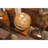 An ornamental wooden ball on stand