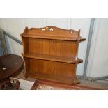 An oak three tier hanging wall shelf