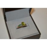 A silver emerald and peridot set ring