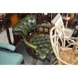 A buttoned down green leather upholstered swivel o