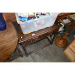 An oak and linen fold decorated table, fitted sing