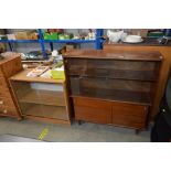 A teak cabinet with glass sliding doors together w