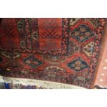 An approx. 5ft 8ins x 2ft 10ins red patterned rug