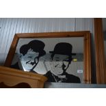 A pine framed mirror depicting Laurel & Hardy