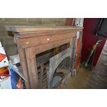 A cast iron fireplace with pine fire surround