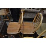 A pair of Ercol stick back chairs