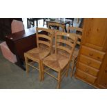 A set of four beech and rush seated kitchen chairs