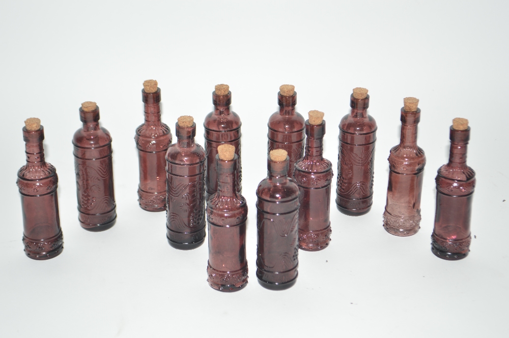 Twelve violet glass small bottles