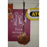 An Antique copper warming pan with turned wooden h