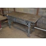 A large cast iron based work-bench with wooden top