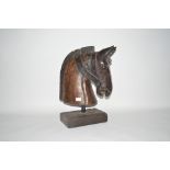 A carved wooden horse's head on stand, 22ins high