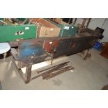 An early 20th Century wooden work bench with two v