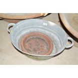 A small galvanised bath and a terracotta plant pot
