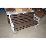 A cast metal garden bench with lion's head decorat