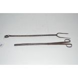 A 19th Century metal meat fork and a pair of tongs