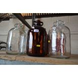 Two brown glass and four clear glass demi johns