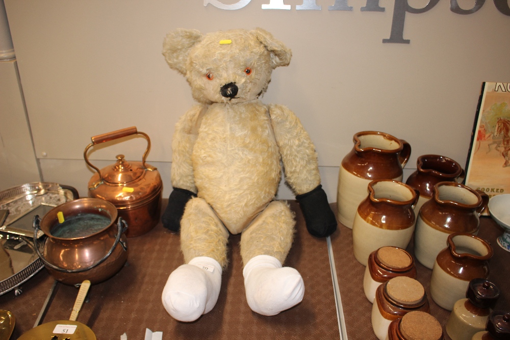 A large vintage Teddy bear with adjustable arms an