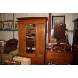 An Edwardian mahogany single door mirrored wardrob