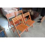 A set of four teak garden folding chairs