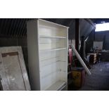 A white painted open fronted bookcase