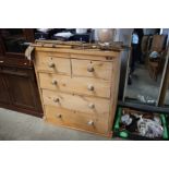 A stripped pine chest fitted two short over three drawers