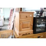 A pine bedside cupboard fitted single drawer