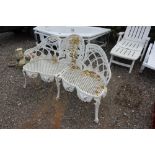 An ornate white painted metal garden bench