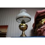 A brass oil lamp with milk glass shade