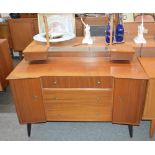 A teak dressing table, fitted four central drawers