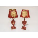 A pair of red Toleware lamps and shades, decorated