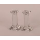 A pair of glass square column candlesticks, raised