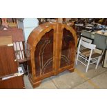 An Art Deco walnut display cabinet, of arched form