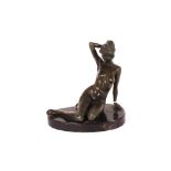 A bronze figure of a seated naked girl, on marble