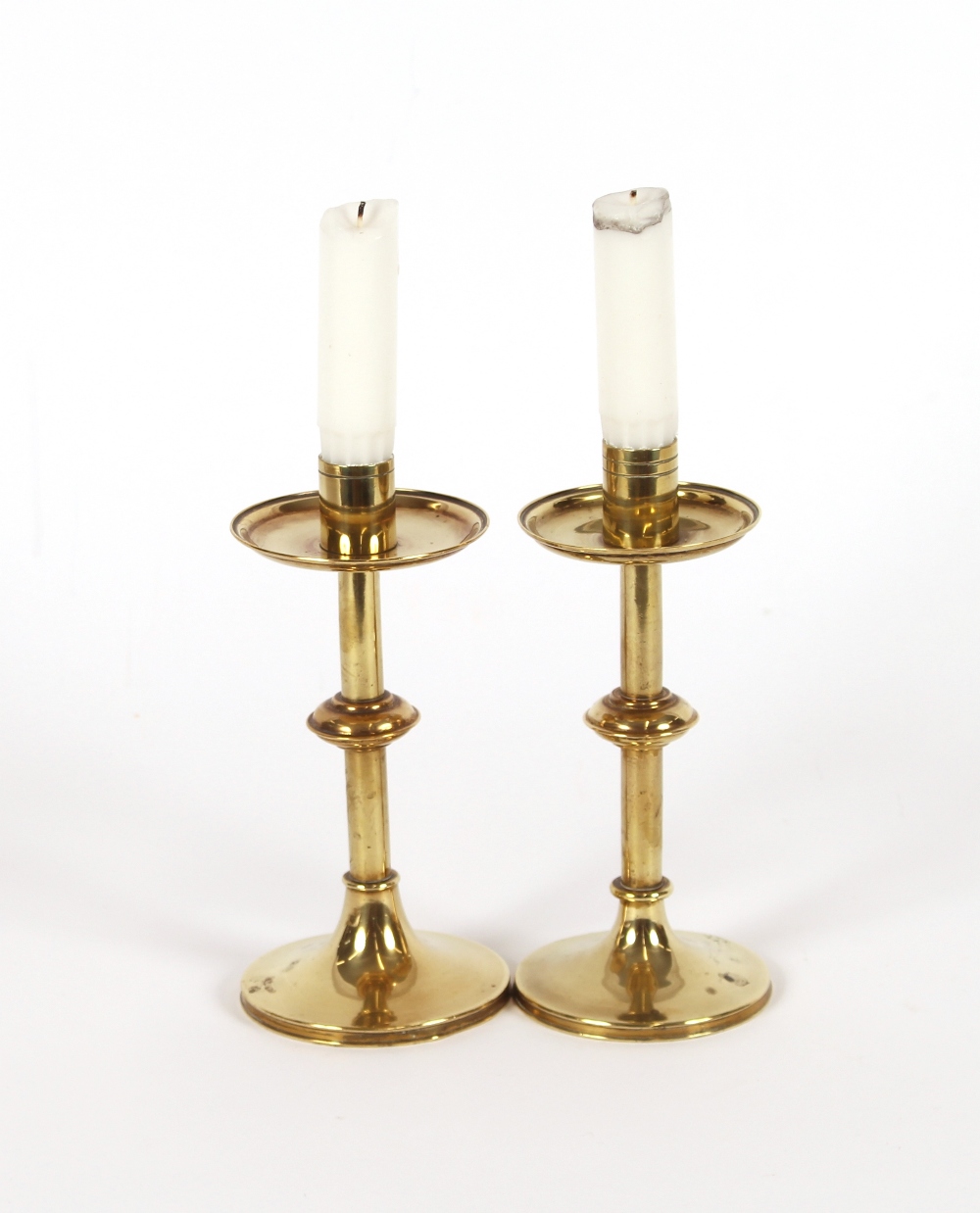 A pair of brass Arts & Crafts design candlesticks