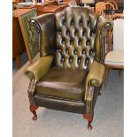 A pair of leather winged back club chairs, with de