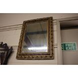 An ornate gilded framed wall mirror