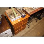 A pine effect bedside chest fitted three drawers