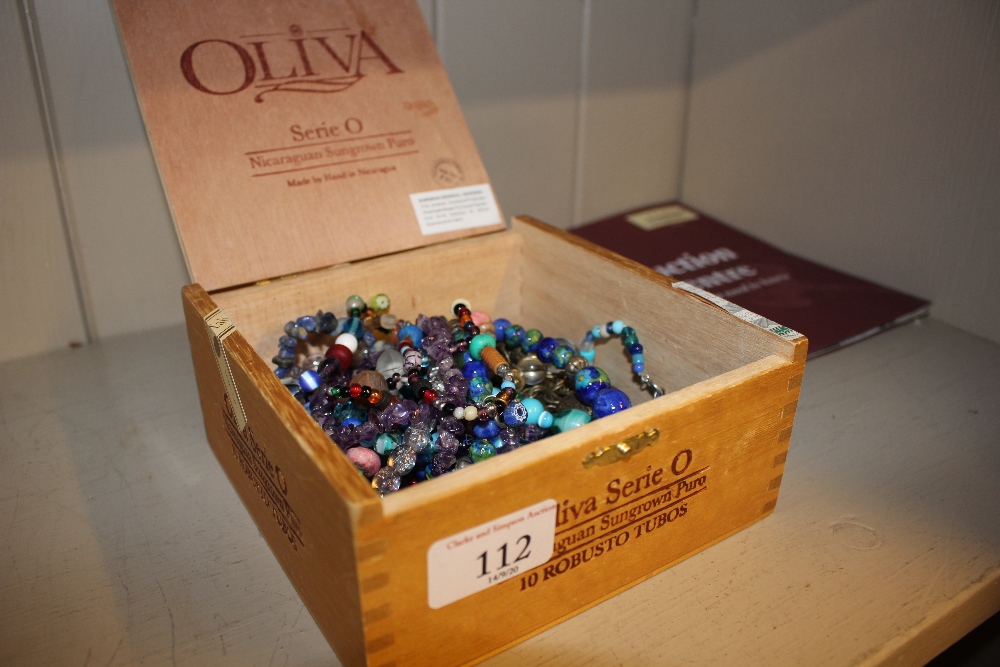 A wooden box and contents of various beads