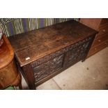 An 18th Century oak panelled coffer with carved de