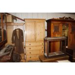 A large stripped pine housemaids cupboard raised o