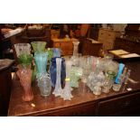A quantity of various coloured glass vases; clear