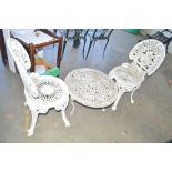 An ornate pair of chairs and similar table