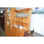 A pine dresser raised on cupboard base fitted thre